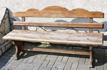 Image showing Old wooden vintage empty bench standing on an open paved area