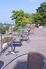 Image showing Wicker chairs with metal legs and racks are in an open cafe area