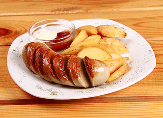 Image showing grilled sausages with French fries and ketchup