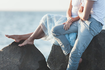 Image showing Happy young romantic couple relaxing on the beach and watching the sunset