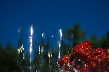 Image showing Strawberries and two blurred glasses outdoors