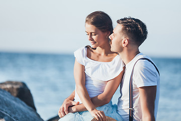 Image showing Happy young romantic couple relaxing on the beach and watching the sunset