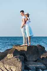 Image showing Happy young romantic couple relaxing on the beach and watching the sunset