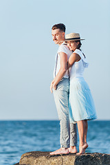 Image showing Happy young romantic couple relaxing on the beach and watching the sunset