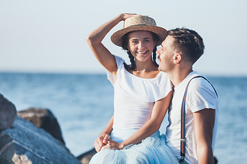 Image showing Happy young romantic couple relaxing on the beach and watching the sunset