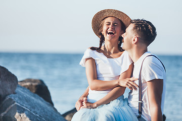 Image showing Happy young romantic couple relaxing on the beach and watching the sunset