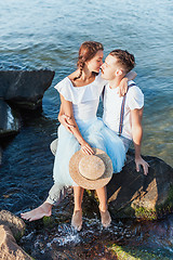 Image showing Happy young romantic couple relaxing on the beach and watching the sunset