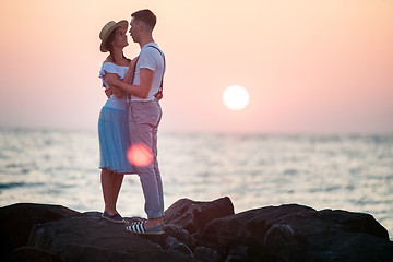 Image showing Happy young romantic couple relaxing on the beach and watching the sunset