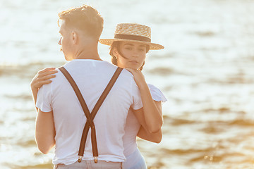 Image showing Happy young romantic couple relaxing on the beach and watching the sunset