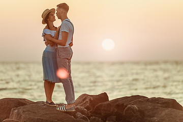 Image showing Happy young romantic couple relaxing on the beach and watching the sunset