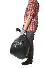 Image showing Man holding black plastic trash bag in his hand