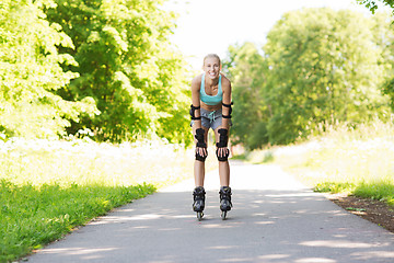 Image showing happy young woman in rollerblades riding outdoors