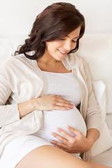 Image showing happy pregnant woman lying on bed at home