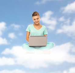 Image showing happy young woman with laptop sitting on cloud