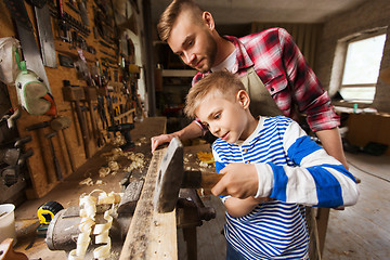 Image showing father and son with hammer working at workshop