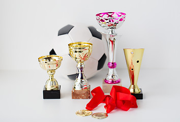 Image showing close up of football ball, golden cups and medals