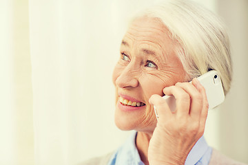 Image showing senior woman with smartphone calling at home