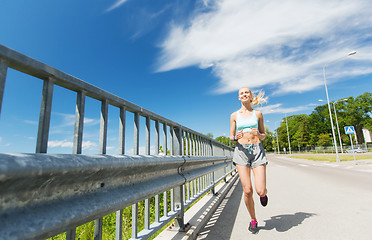 Image showing smiling young woman running outdoors