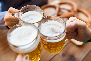 Image showing close up of hands with beer mugs at bar or pub