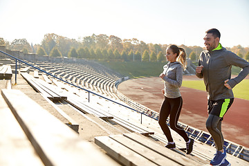 Image showing happy couple running upstairs on stadium