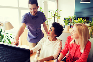 Image showing happy creative team with computer in office