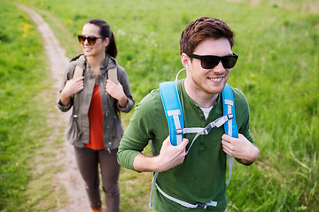 Image showing happy couple with backpacks hiking outdoors