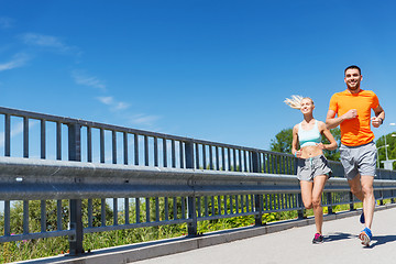 Image showing smiling couple running at summer seaside