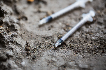 Image showing close up of used drug syringes on ground