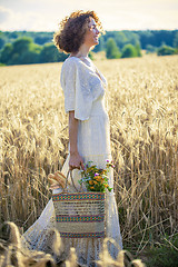 Image showing Woman Outdoors with wicker bag with natural meal 