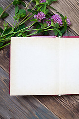 Image showing Top view of open book photo album with clover flowers