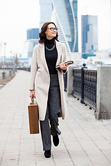 Image showing beautiful smiling woman in a white coat with a wooden case and b