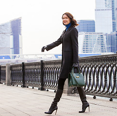 Image showing smiling pretty middle-aged woman in a fashionable dark coat