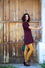 Image showing Smiling beautiful middle-aged woman dressed in a burgundy dress