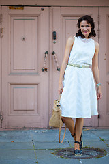 Image showing smiling dark-haired middle-aged woman dressed in a light summer 