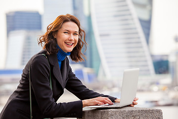 Image showing portrait of a beautiful laughing woman with a laptop