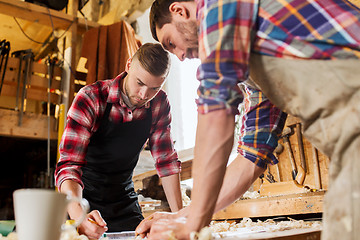 Image showing carpenters with ruler and blueprint at workshop