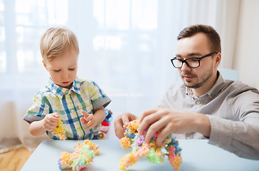 Image showing father and son playing with ball clay at home