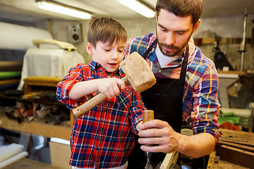 Image showing father and son with chisel working at workshop