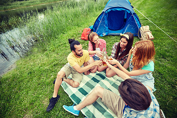 Image showing happy friends with tent and drinks at campsite