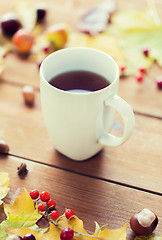 Image showing close up of tea cup on table with autumn leaves