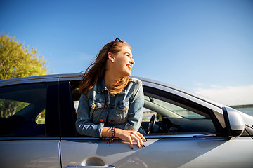 Image showing happy teenage girl or young woman in car