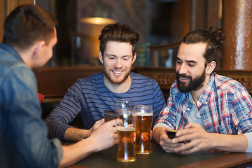 Image showing male friends with smartphones drinking beer at bar