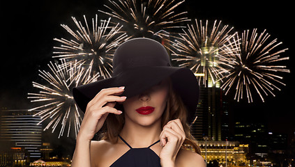 Image showing beautiful woman in black hat over night firework