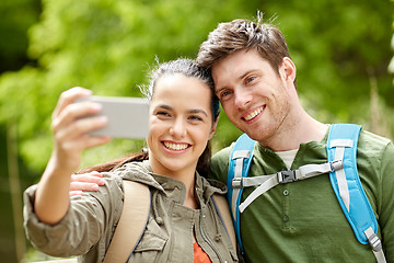 Image showing couple with backpacks taking selfie by smartphone