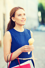 Image showing woman with shopping bags and ice cream in city