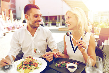 Image showing happy couple eating dinner at restaurant terrace