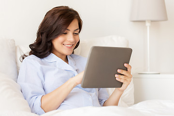 Image showing happy pregnant woman with tablet pc at home