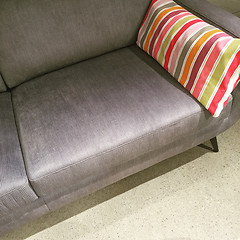 Image showing Gray sofa with colorful striped cushion