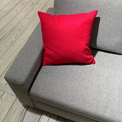 Image showing Classic gray sofa with vibrant red cushion