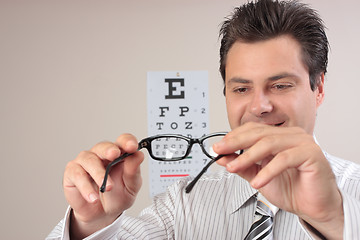 Image showing Optometrist examining eye glasses